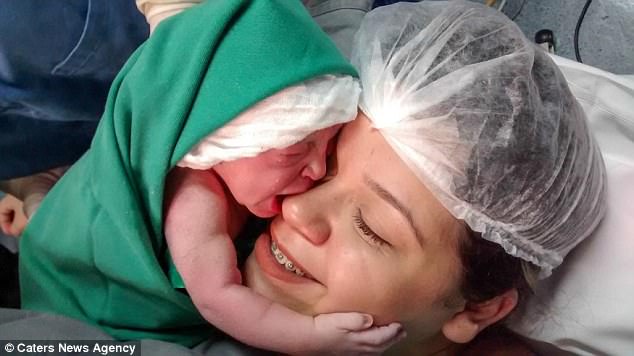 Новорожденная малышка обнимает мамино лицо